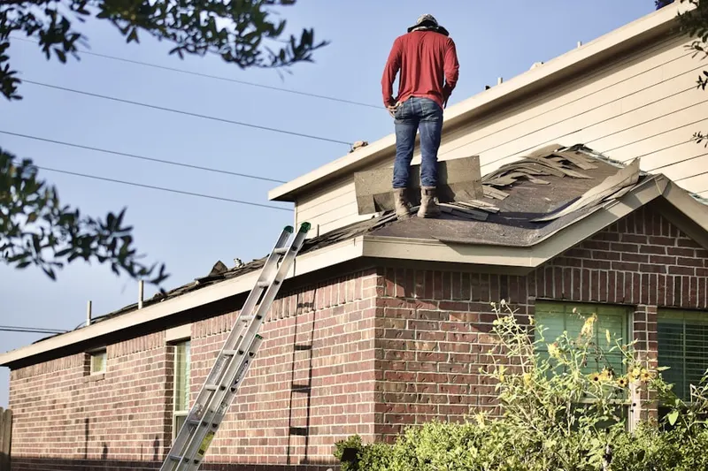 Professional roofer working on a residential roof in Anniston
